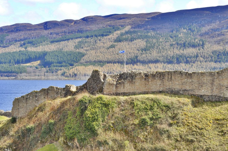 Castle Urquhart flying the Scottish flag